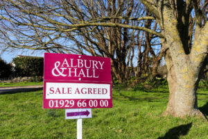 A 'Sale Agreed' Albury & Hall estate agent sign in Swanage