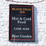 Sign outside the Black Swan Inn in Swanage advertising ales, food and beer garden
