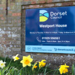 Daffodils in front of a sign outside Dorset Council's Westport House