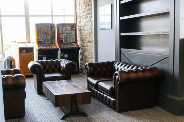 Leather sofa seating area and fruit machines int he bar of Swanage Bay View Holiday Park