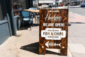 'We are open' signage outside Swanage's Harlees on Station Road