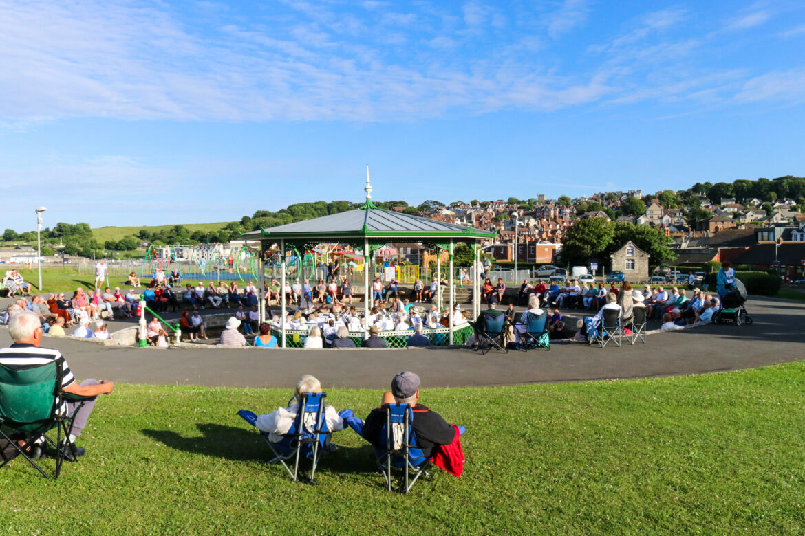 People watching Swanage Town Band performing in the 1920s bandstand