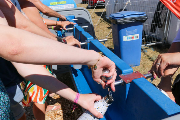 People filling up their water bottles at the free hydration stations at Camp Bestival