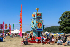 Kids exploring the 8m-tall robot at 2022's Camp Bestival