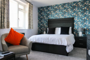 Double bed & tub chair of hill-facing room at The Pines, Swanage